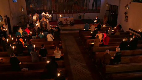 Stimmungsvolle Atmosphäre bei der Auferstehungsfeier am Ostersonntag früh, solange nur die Osterkerzen den Kirchenraum beleuchten.