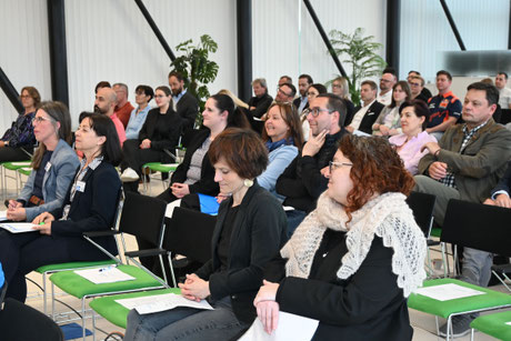 Mehrere Reihen mit konzentrierten Zuhörerinnen und Zuhörern