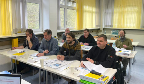 Teilnehmer schreiben mit und arbeiten konzentriert an Arbeitsunterlagen im Workshop „Du kannst was“