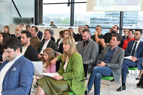 Teilnehmende verfolgen interessiert der Präsentation.