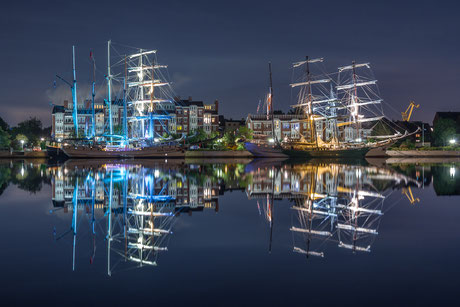 Beleuchtete Segelschiffe beim Wilhelmshaven-Sailing-Cup in Wilhelmshaven mit Spiegelung im Wasser