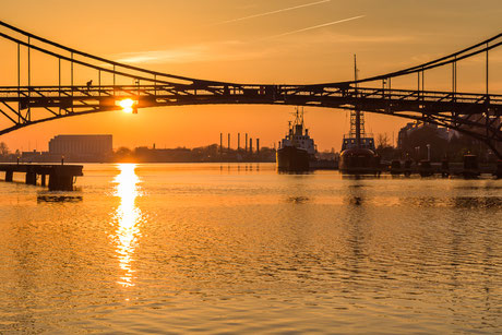 Sonnenuntergang Kaiser-Wilhelm-Brücke in Wilhelmshaven mit Blick auf das Feuerschiff Weser und den Tonnenleger Kapitän Meyer und das Atlantic Hotel