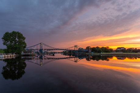 Sonnenuntergang mit einem dramatischen Himmel an der Kaiser-Wilhelm-Brücke in Wilhelmshaven