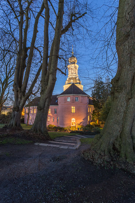 Rückseite Schloss Jever in Friesland zur Blauen Stunde mit Bäumen im Vordergrund