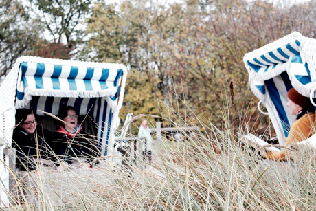 bei einer ungewöhnlichen Trauung mitten in den Dünen in Boltenhagen, zwei Strandkörbe stehen sich gegenüber. Im einen das schallend lachende Brautpaar um anderen Constanze Marienfeld während der Traurede. 