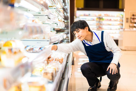 スーパー内で品出しをしている男性スタッフの画像