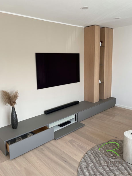 Moderner TV-Wohnzimmerschrank mit Lowboard und raumhoher Wohnwand in Eiche furniert mit praktischen Stauraumlösungen nach Kundenwunsch wie Klappen für Receiver und fingergezinkte Eiche Massivholz Schubladen 