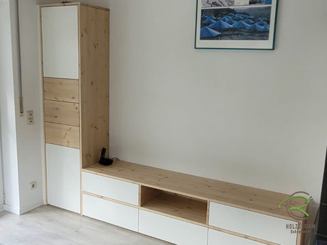 Schrankwand für Wohnzimmer in L-Form mit niedrigem Lowboard und hohem Schrank für Gläser und Dekoration, weiß und Fichte gekalkt mit offenem Regalfach, Schubladen und Klappen
