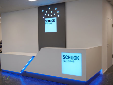 Verkausfstheke in weiß mit indirekter LED-farbwechslender RGB-Beleuchtung, weiße Empfangstheke in L-Form mit beleuchteter Logo-Gestaltung mit einem Lightpanel