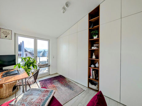 Raumhoher Einbauschrank nach Maß unter einer Dachschräge mit offenem Regal in Villingen-Schwenningen