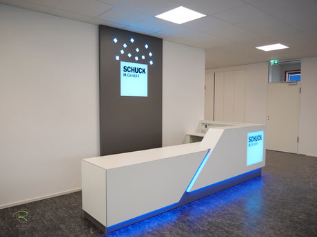 Empfangsbereich mit Verkaufstheke in weiß mit indirekter LED-farbwechslender RGB-Beleuchtung, weiße Empfangstheke in L-Form mit beleuchteter Logo-Gestaltung mit einem Lightpanel von Schreinerei Holzdesign Ralf Rapp in Geisingen