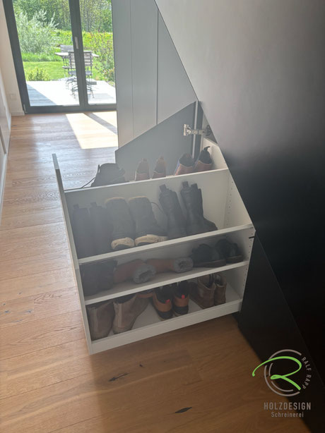 Maßgefertigter Einbauschrank vom Schreiner im Treppenverlauf mit beidseitig nutzbare Schuhauszug, der die komplette Tiefe der Treppe ausnutzt