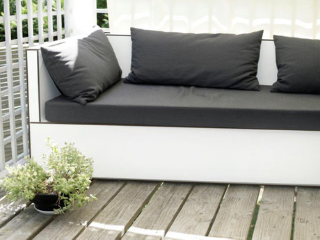 Individuell gefertigte Balkon-Lounge aus Vollkernplatten mit wetterfesten Outdoor-Polstern als platzsparende Sitz- und Liegelösung für einen kleinen Balkon. 