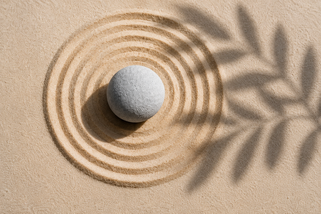 Stein mit kreisförmigen Linien im Sand als Symbol für Solarhoroskop und astrologische Jahresthemen