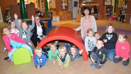 Filialleiterin Jana Panten (li) und Kita-Leiterin Astrid Beste (re) freuen sich mit den Kindern über die neuen Spielgeräte.