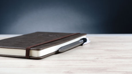 Geschlossenes noch leeres Notizbuch auf Tisch liegend