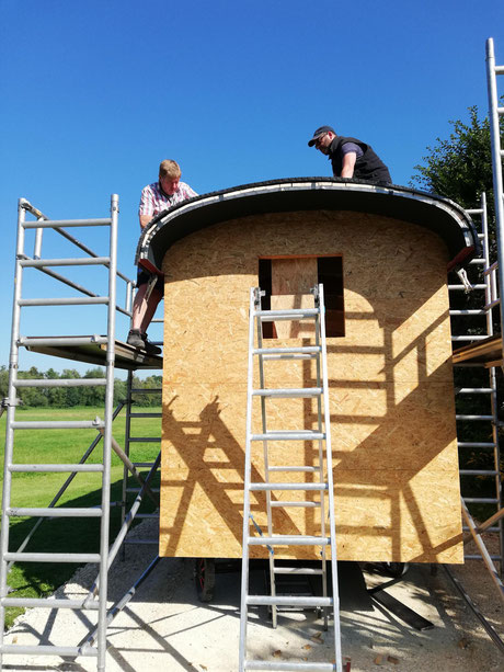 Der Schäferwagen bekommt sein Dach. Christoph Foag (Dachdeckermeister) und Roland bei der Montage der Dachbleche.