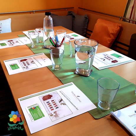 Gedeckter Tisch mit Wassergläsern und Schulungsunterlagen