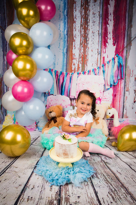 Meisje kijkt schattig tijdens cake smash shoot