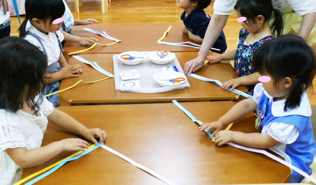 幼児教室の幼稚園児クラスで父の日のプレゼントを制作。腕時計のベルト用に短冊を三つ編みしました。