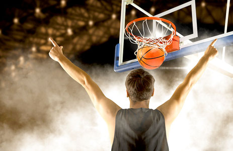 Basketballspieler jubelt nachdem er einen Korb nach erfolgreichem Korbwurf