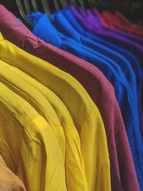 Chemises de couleur vive accrochées sur un portant, pour illustrer l'article de blog mariage "invité.e de mariage : quelles règles respecter et quelques conseils", par My Daydream Wedding, wedding planner et designer à Lille, Paris et la France