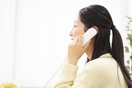 電話で問い合わせをする女性