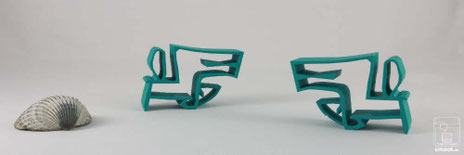 3D-Druck chimaumau in den Varianten Pfote links Pfote rechts stehen sich gegenüber. Farbe Türkis. Hintergrund grau. Muschel links im Bild