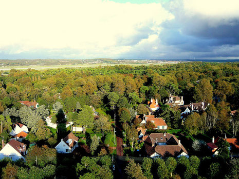 Au Nord-Est : l'ombre portée du phare sur le tapis forestier et les villas - Automne