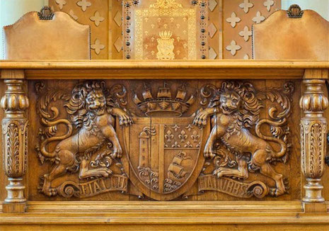 Les armories du Touquet-Paris-Plage, gravées sur le devant de la tribune de la salle du conseil municipal à l'hôtel de ville, rappellent , par l'image du phare, le sens de la devise Fiat lux, fiat urb