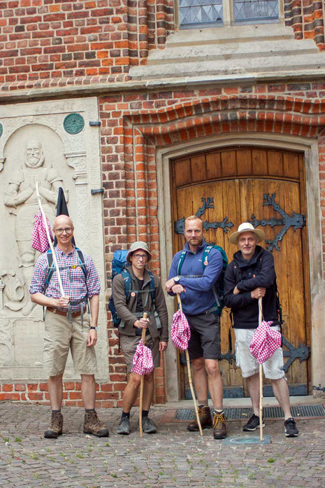 Foto mit vier Personen vor dem Eingang einer Kirche