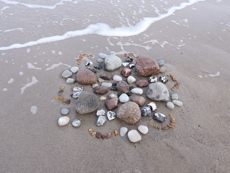 Mandala aus Steinen am Strand