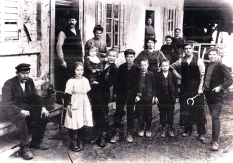 Abb.3: Noch heute heisst die Strasse zwischen der ehemaligen Brauerei und der Bäckerei «Schmittenweg.» Das Bild zeigt die Schmiedefamilie Wyss am Schmittenweg in den 1920er-Jahren.