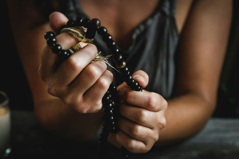 Hand hält eine handgeknüpfte Mala – Ausdruck von Achtsamkeit, Spiritualität und Verbindung nach innen