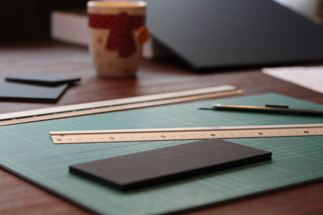 Tisch mit Foamcoreplatten, Lineal und Cuttermesser für den Bau von Brettspieleinsätzen und Inserts
