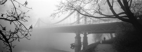 Foggy scene with a bridge over the river.