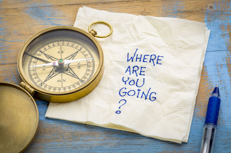 Ein Kompass, der auf einer Serviette liegt. Auf dieser steht: Where are you going?