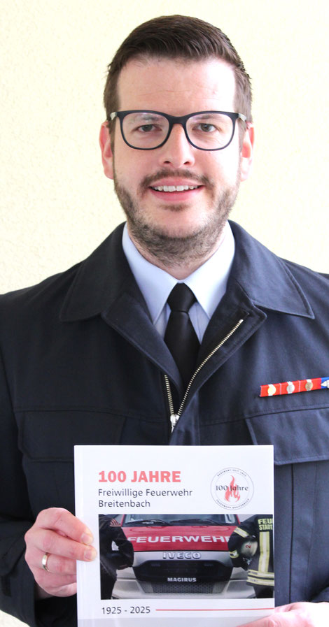 Vorsitzender Tobias Christ präsentiert die Festschrift zum 100jährigen Jubiläum.
