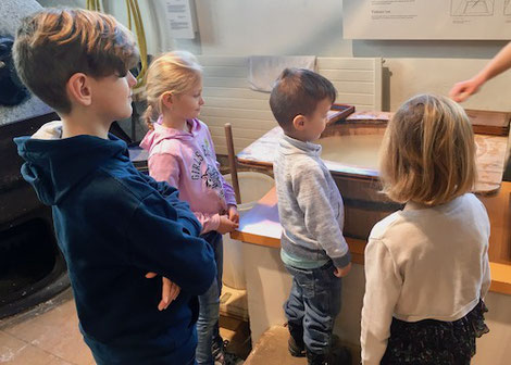 Kinder schauen beim Papierschöpfen zu