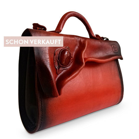 Dekorative Mineralien in der Mode: Handtasche aus echtem Rindsleder in Bordeaux-rot mit eingearbeitetem Edelstein.