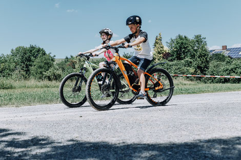 Zwei Kinder auf e-Mountainbikes von R Raymon