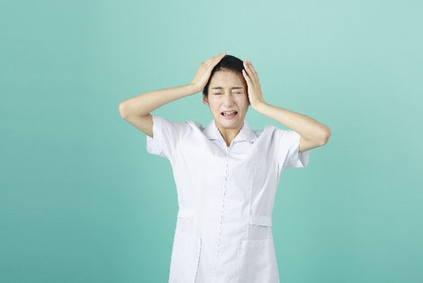 頭を抱える女性薬剤師の画像