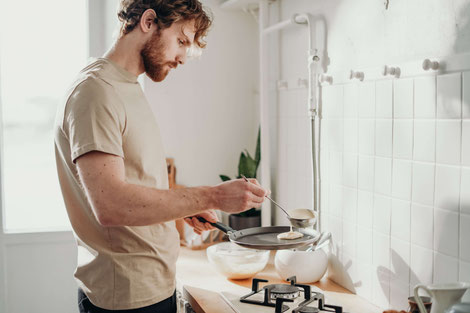 MAN COOKING ALONE IN THE KITCHEN