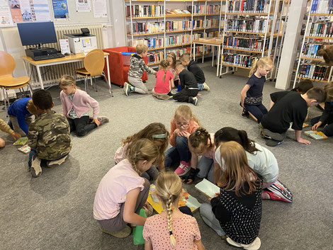 Die Kinder arbeiten in Gruppen in der Stadtbibliothek