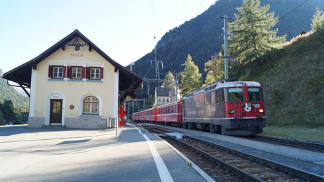 Der Regionalzug mit vorgespannter Ge 4/4 II, im Werbekleid 100 Jahre Eisenbahnstrecke Bever-Scuol, im Bahnhof Susch