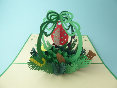 Carte de noël en pop-up avec un panier de noël de houx et cadeaux garnis