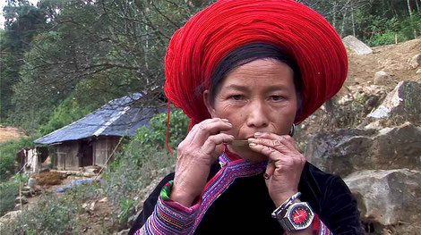 Vang Thi Sang jouant la guimbarde ncas. On remarquera l’étui en bambou de l’instrument dans sa main gauche. © Patrick Kersalé 2010-2024.