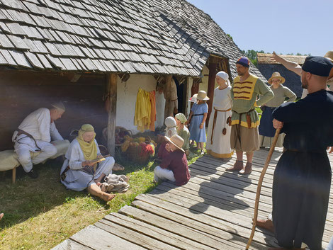Eine Gruppe Färber und Färberinnen zeigt dem Gefolge, wie im Mittelalter Stoffe und Garn gefärbt wurde.