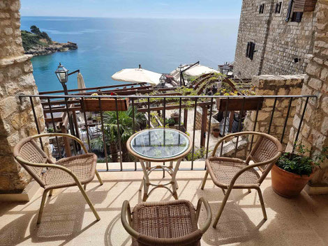 Stone balcony with wicker furniture overlooking the Adriatic Sea in Palata Venezia Ulcinj, Montenegro, featuring historic castle walls and crystal blue waters perfect for a luxury coastal vacation