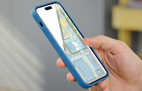Eine Hand hält ein Smartphone. Auf dem Smartphone ist in einer Event-App der Lageplan von einer Veranstaltungs-Location zu sehen.